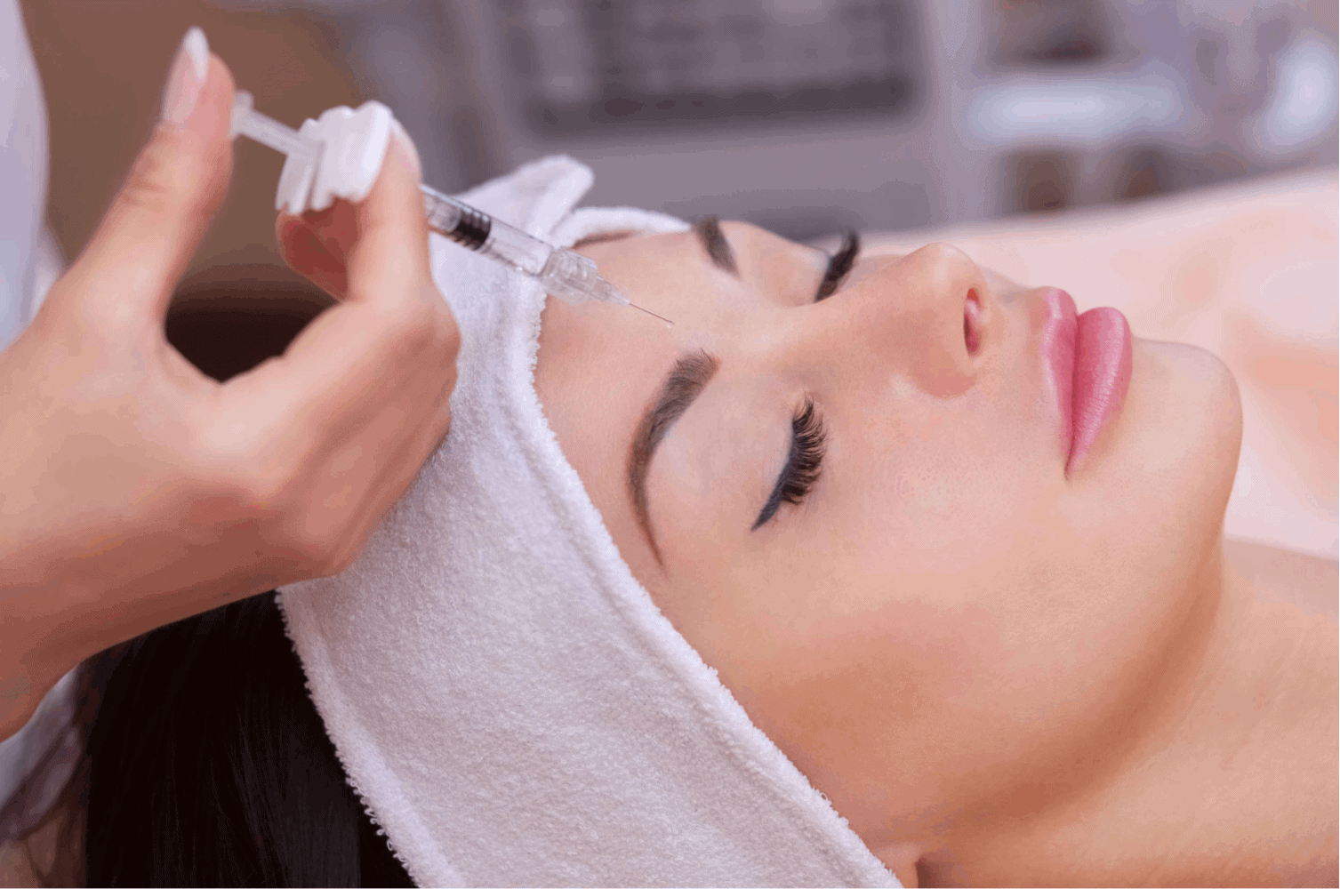 Woman receiving dermal filler injections at Homa Rejuvenation in Altamonte Springs, FL with a syringe placed near the forehead during treatment.